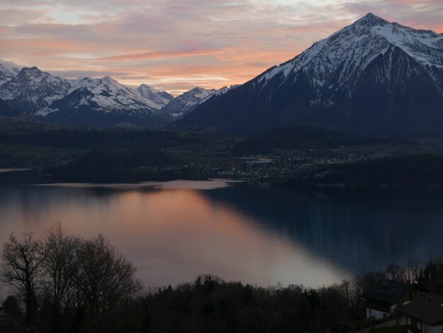 Bella ripresa di una ripida montagna con il bianco della neve sulla vetta con uno scenario di tramonto nel cielo