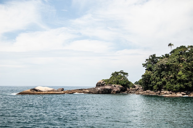 Bella ripresa di una spiaggia con colline boscose a Ilha Grande, Brasile