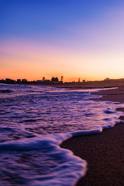 Bella ripresa di uno scenario del tramonto sulla spiaggia con un cielo limpido