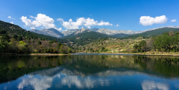 Bella ripresa panoramica di un lago con montagne e alberi sullo sfondo