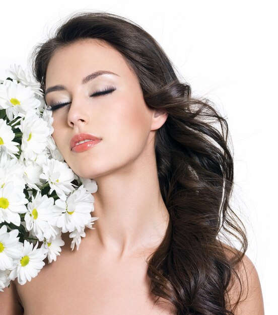 Bella sensualità giovane donna con gli occhi chiusi e fiori bianchi - sfondo bianco