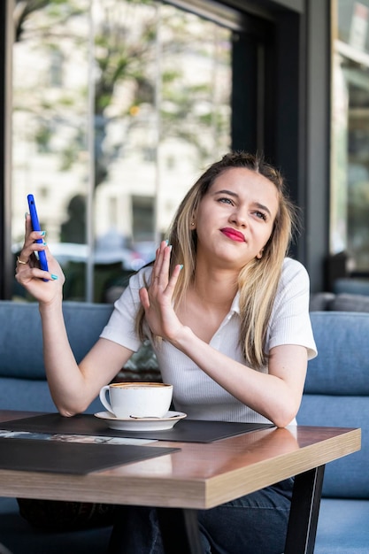 Bella signora che tiene il telefono e non vuole guardarlo