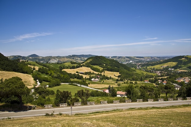 Bella strada lungo le case rurali con un paesaggio montuoso