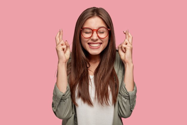 Bella studentessa in posa contro il muro rosa