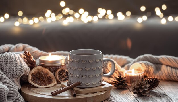 Bella tazza di Natale e candele su sfondo sfocato con bokeh