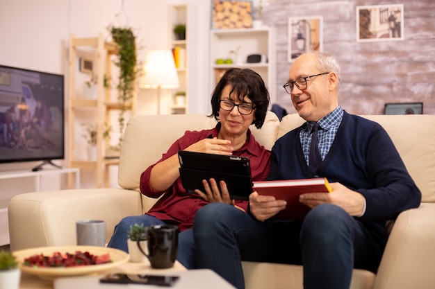 Bella vecchia coppia che utilizza una tavoletta digitale per chattare con la propria famiglia. Anziani che utilizzano la tecnologia moderna