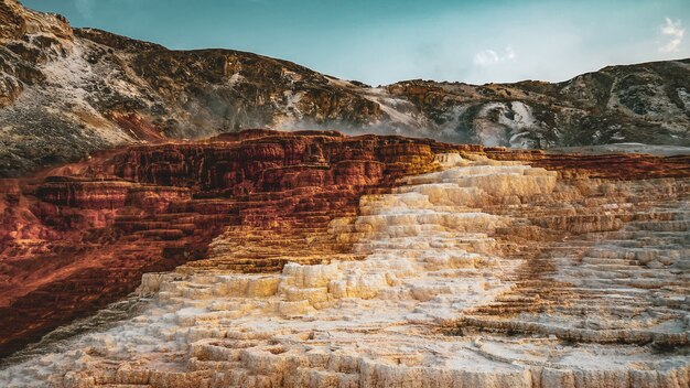 Bella vista degli strati di vecchie rocce circondate dalle montagne sotto il cielo blu