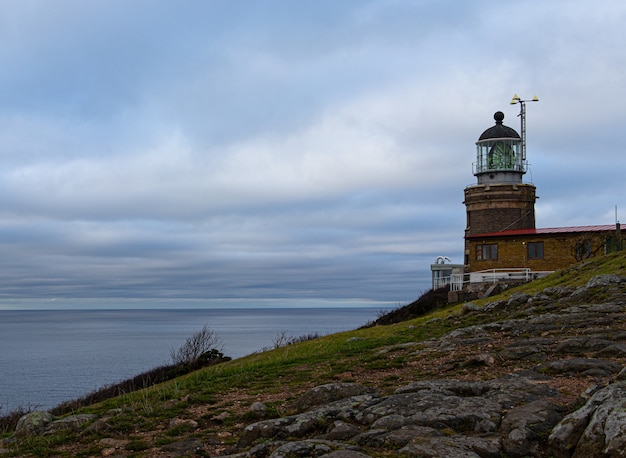 Bella vista del faro di Kullaberg in Svezia con l'oceano e il cielo nuvoloso