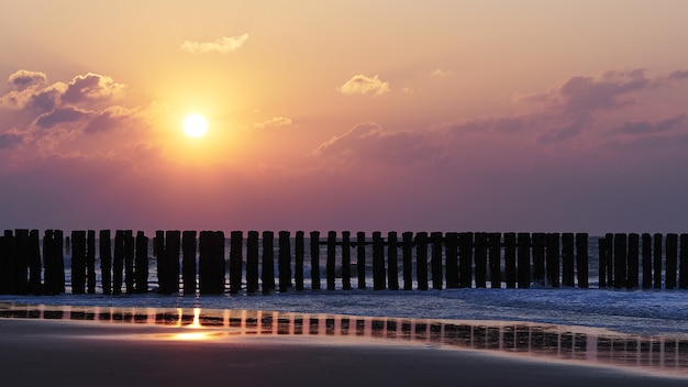 Bella vista del tramonto con nuvole viola sopra la spiaggia