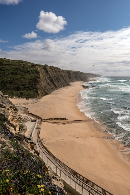 Bella vista della spiaggia di sabbia con un sentiero sulla scogliera
