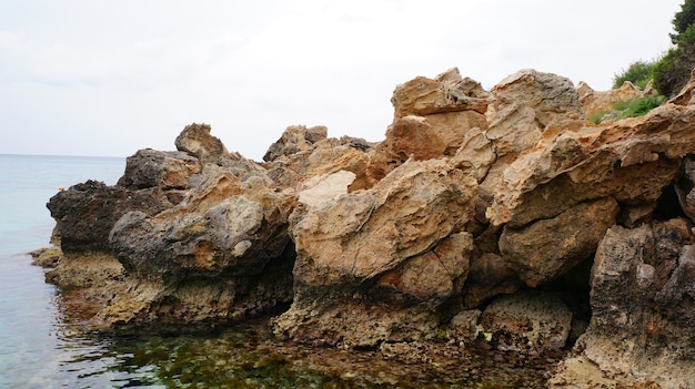 Bella vista di una spiaggia rocciosa con l'oceano e il cielo blu