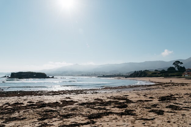 Bella vista sulla spiaggia con le montagne sullo sfondo in una giornata di sole