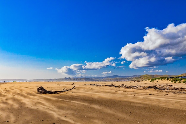Bella vista sulla spiaggia di sabbia sul mare sotto le magnifiche nuvole nel cielo