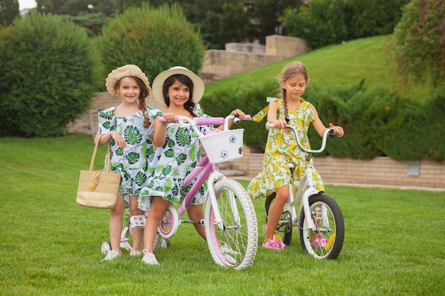 Belle bambine in sella a una bicicletta attraverso il parco. Natura, stile di vita