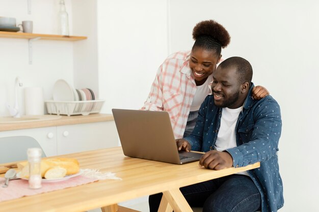 Belle coppie che esaminano il loro computer portatile