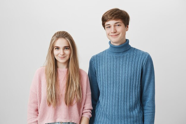Belle coppie felici che indossano maglioni lavorati a maglia caldi