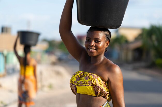 Belle donne africane che vanno a prendere l'acqua da fuori