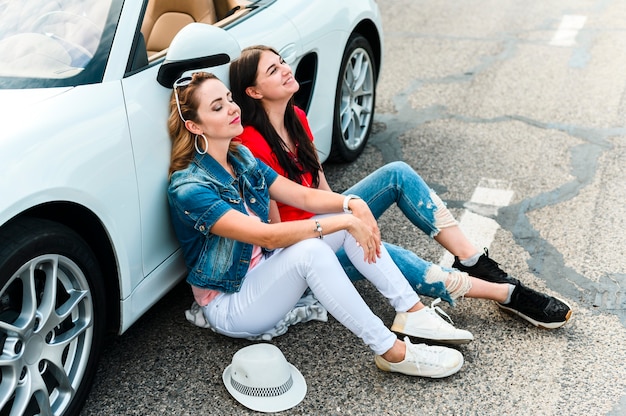 Belle donne che si siedono a colpo pieno