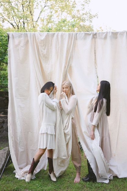 Belle donne che stanno in vestito bianco in giardino.