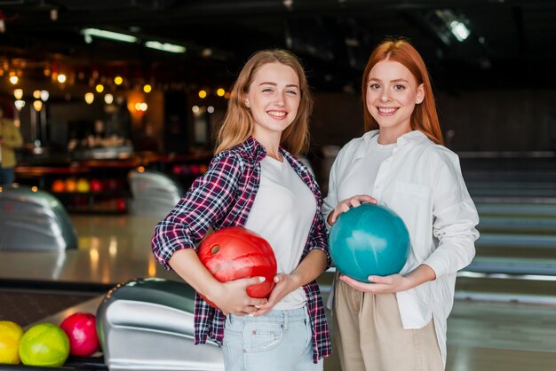 Belle donne che tengono le palle da bowling