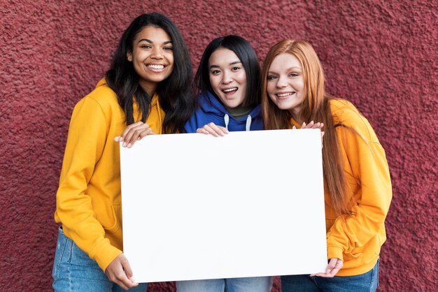 Belle donne che tengono una scheda in bianco