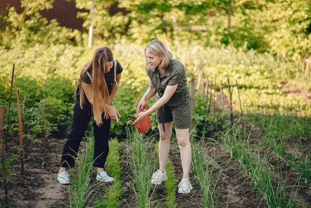 Belle donne lavora in un giardino vicino alla casa