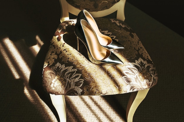 Belle eleganti scarpe da sposa argento elegante sulla sedia