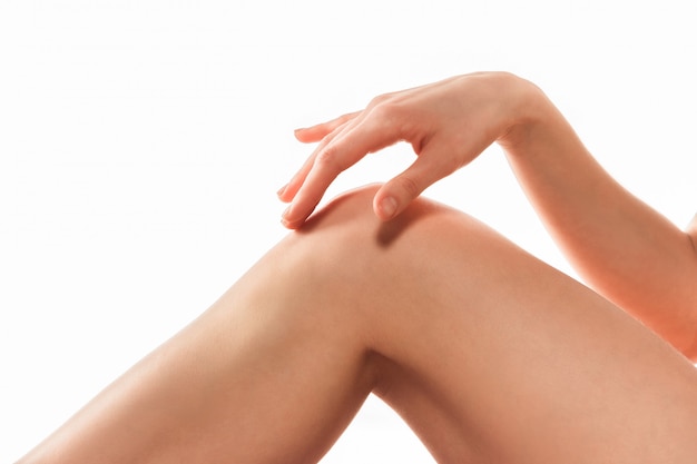 Belle gambe femminili isolate su bianco. Concetto di bellezza e fitness