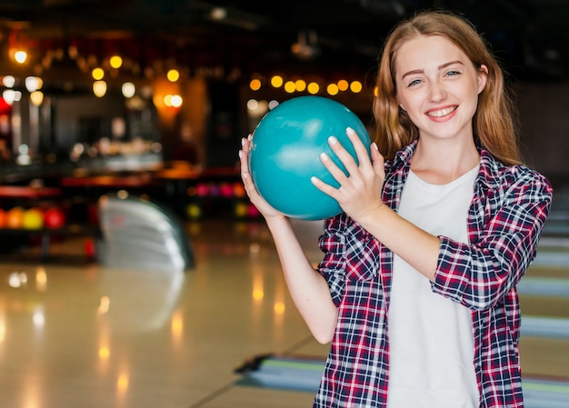 Belle giovani donne che tengono una palla da bowling