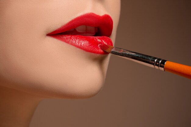 Belle labbra femminili con trucco e pennello