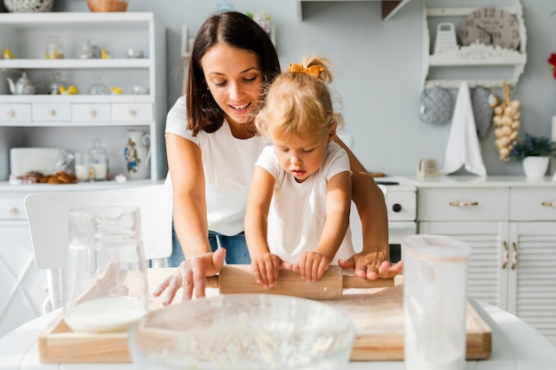 Belle madre e figlia che usando il rullo della cucina