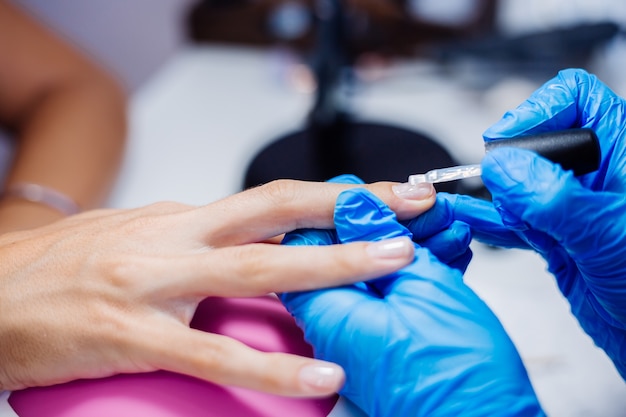 Belle mani femminili Processo di fabbricazione di trattamento delle unghie delle dita Trapano lima professionale per unghie in azione Concetto di cura delle mani e di bellezza