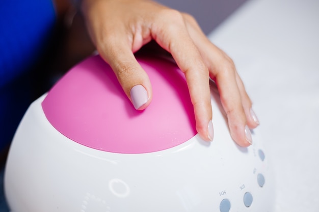 Belle mani femminili Processo di fabbricazione di trattamento delle unghie delle dita Trapano lima professionale per unghie in azione Concetto di cura delle mani e di bellezza