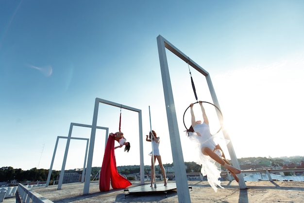 Belle ragazze che eseguono pole, aerial e hoop dance sul tetto