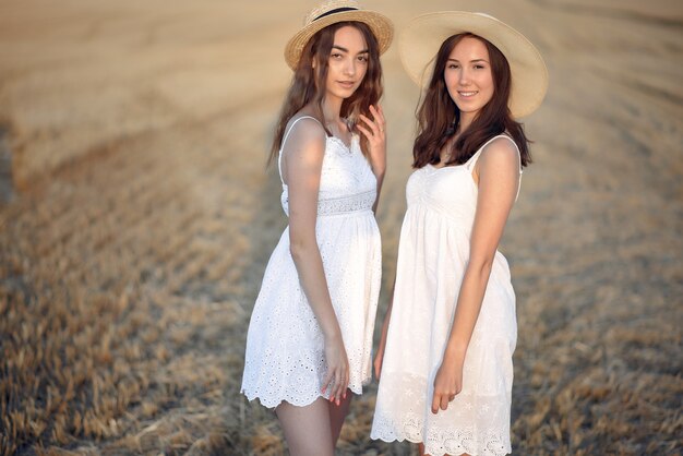 Belle ragazze eleganti in un campo di grano in autunno