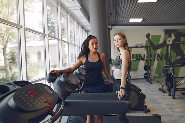 Belle ragazze in una palestra. Donne sportive in abbigliamento sportivo. Amici in una pista da corsa.