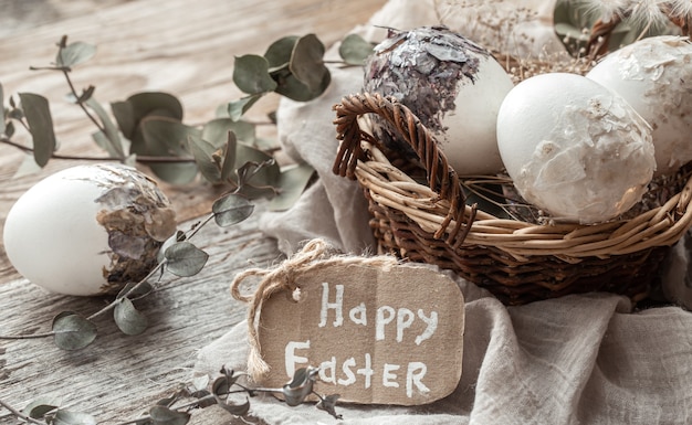 Belle uova di Pasqua in un cesto decorato con fiori secchi. Felice Pasqua concetto.