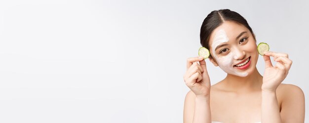 Bellezza giovani donne asiatiche immagine di cura della pelle con cetriolo su sfondo bianco studio