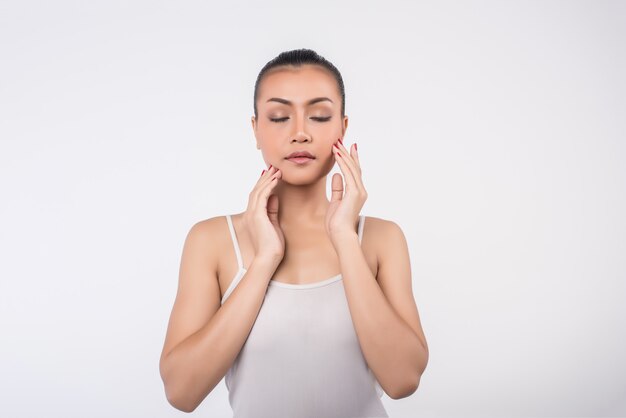 Bellissima giovane donna con la pelle pulita fresca tocco proprio viso