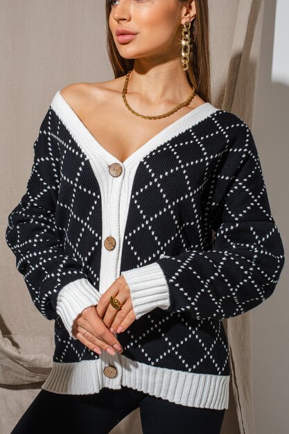 Bellissima modella che indossa un cardigan a scacchi bianco e blu scuro