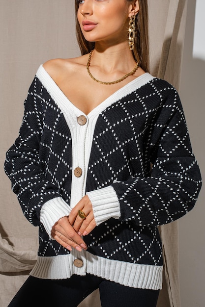 Bellissima modella che indossa un cardigan a scacchi bianco e blu scuro