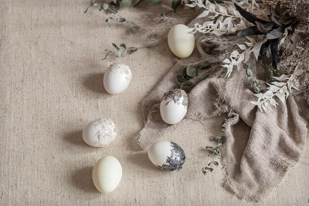 Bellissime uova di Pasqua sparse sul tessuto strutturato. Concetto di arredamento di Pasqua.