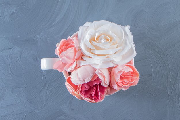 Bellissimi fiori in una tazza, su fondo bianco. Foto di alta qualità