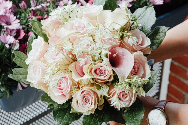 Bellissimo bouquet con rose rosa e foglie verdi