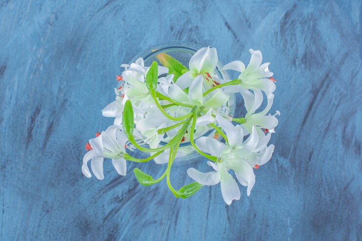 Foto gratuito bellissimo bouquet di fiori di giglio in un vaso di vetro sul blu.