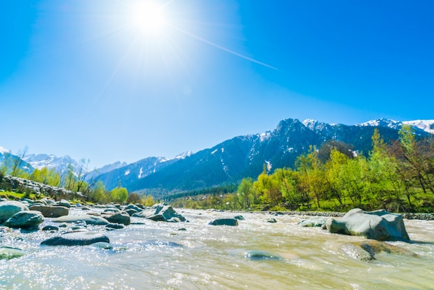 Bellissimo fiume e neve coperto montagne paesaggio dello stato di Kashmir, India.