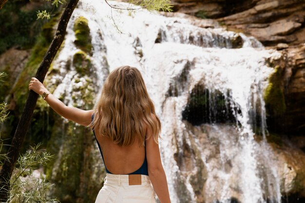 Bellissimo giovane adulto vicino alla cascata