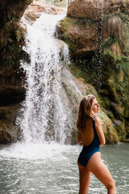 Bellissimo giovane adulto vicino alla cascata