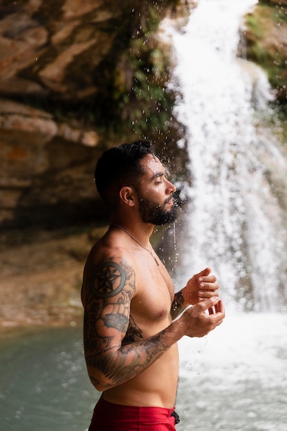 Bellissimo giovane adulto vicino alla cascata