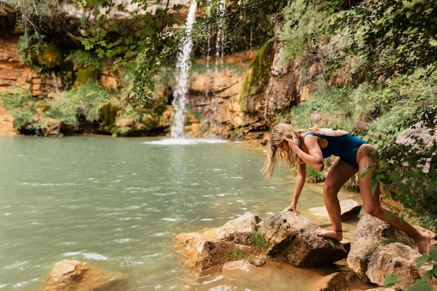 Bellissimo giovane adulto vicino alla cascata